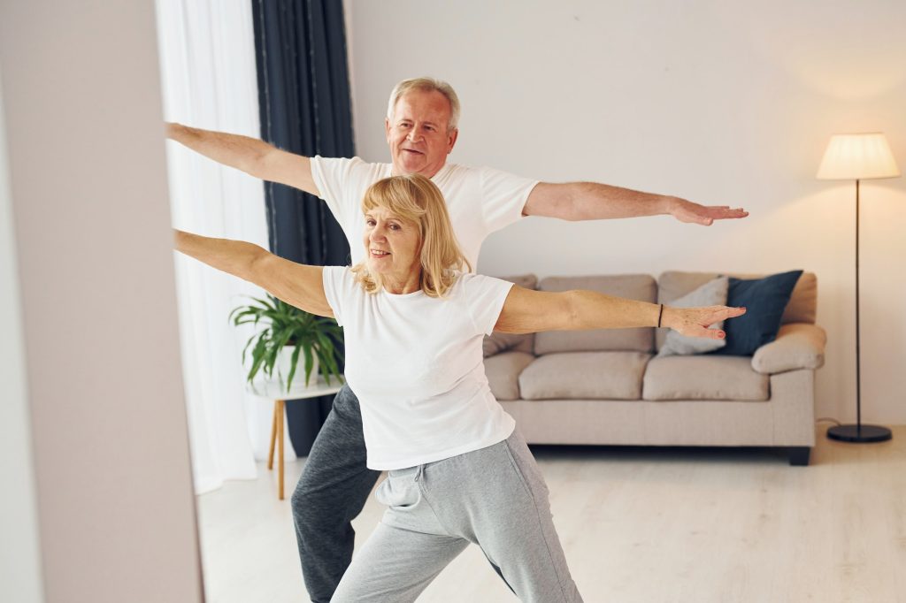 Sportive exercises. Senior man and woman is together at home